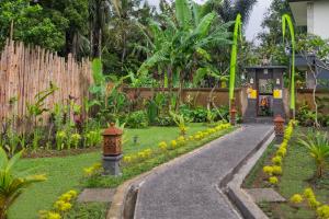 a garden with a walkway in front of a house at Puri Astina Villa in Ubud