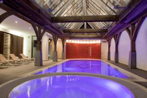 uma grande piscina num edifício com tecto de madeira em Logis Hotel Le Parc & Spa em Saint-Hippolyte