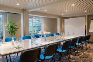 uma sala de conferências com uma mesa longa e cadeiras em Logis Hotel Le Parc & Spa em Saint-Hippolyte