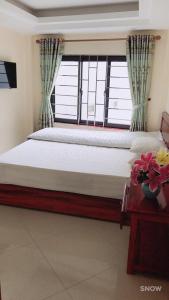 a bedroom with a large bed with a window at Camellia Guest House in Sa Pa