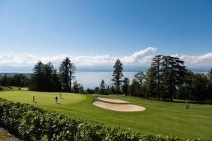 una vista de un campo de golf con personas jugando al golf en Le Manoir du Golf, en Publier