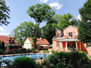 une maison avec une piscine en face d'une maison dans l'établissement Willa Różana, à Nałęczów