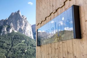 un cartello sul lato di un edificio con una montagna di Sonus Alpis - Adults Only a Castelrotto