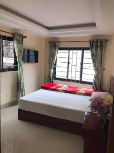 a bedroom with a large bed and windows at Camellia Guest House in Sa Pa