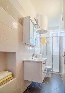 bagno bianco con lavandino e servizi igienici di Apartment Zora & Natale a Pola (Pula)