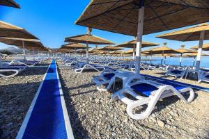 una fila de tumbonas y sombrillas en una playa en Villa Jadran Apartments, en Bar