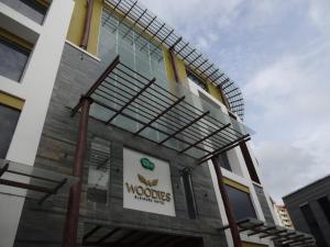 un bâtiment avec un panneau sur son côté dans l'établissement Woodies Bleisure Hotel, à Kozhikode