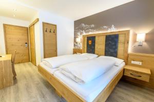 a bedroom with a large bed with white pillows at Hotel & Gasthof Taferne in Schladming