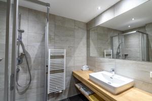 a bathroom with a sink and a shower at Hotel & Gasthof Taferne in Schladming