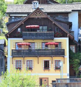 dom z balkonem z czerwonymi parasolami w obiekcie Haus Franziska w Hallstatt