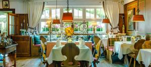 a restaurant with tables and chairs and a chandelier at Hotel & Restaurant Sonne in Kirchzarten