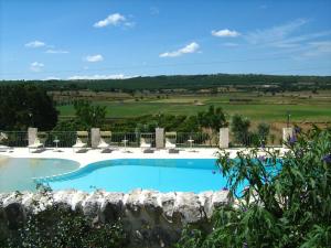 a large blue swimming pool with a stone wall at Masseria Torricella in Alberobello