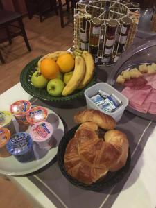 una tabella con due vassoi di diversi tipi di pane e frutta di Hôtel de la Gare a Yvonand