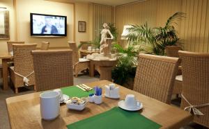 uma sala de jantar com uma mesa e uma estátua de uma mulher em Hotel Stolberg em Wiesbaden