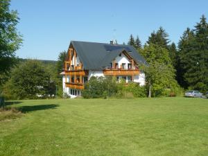 una grande casa con tetto di gambero su un campo di Hotel Bergblick a Warmensteinach