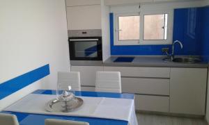 una cocina azul y blanca con mesa y sillas en Mali Šjor, en Primošten