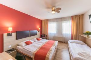 a hotel room with two beds and a ceiling fan at Bon Port in Montreux