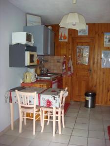 una cucina con tavolo, sedie e piano cottura di Studio avec solarium a Bourg-Saint-Maurice