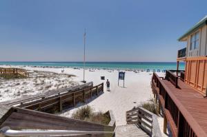 ein Strand mit einem Gebäude und Menschen am Strand in der Unterkunft Beachside Inn in Destin