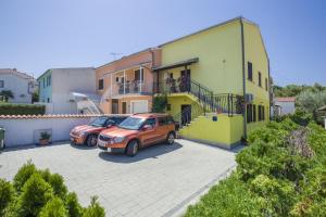 due auto parcheggiate in un parcheggio di fronte a una casa di Apartments Javor a Rovigno (Rovinj)