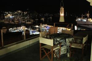 einen Balkon mit einem Tisch und Stühlen sowie einen Yachthafen in der Nacht in der Unterkunft la mansarda sul Porto in Ponza