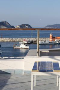 eine Bank auf einem Balkon mit Blick auf einen Wasserkörper in der Unterkunft la mansarda sul Porto in Ponza