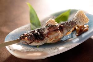 um pedaço de peixe num prato com uma faca em Kinseikan Seseragi em Minakami