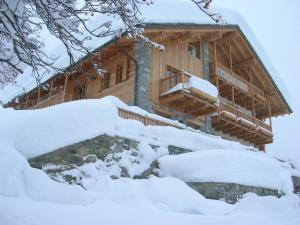 una cabaña de madera en invierno con nieve en las escaleras en Ellex Eco Hotel, en Gressoney-la-Trinité