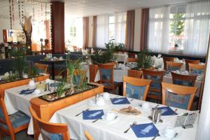 uma sala de jantar com mesas e cadeiras brancas em Trip Inn Hotel Zum Riesen Hanau em Hanau am Main