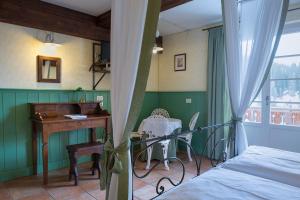 a bedroom with a bed and a desk and a deskablish at Quinz - Locanda Al Lago in Misurina