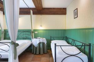 two beds in a room with green walls at Quinz - Locanda Al Lago in Misurina