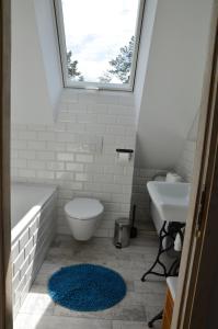 a bathroom with a sink and a toilet and a window at Kaszubówka 22 in Załakowo