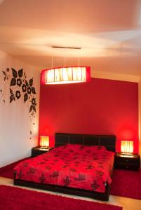 um quarto vermelho com uma cama e 2 candeeiros em Tsentralniy Hotel em Khmelnytskyi