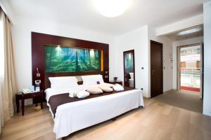 1 dormitorio con 1 cama grande y una gran pintura en la pared en Mercure Olbia, en Olbia