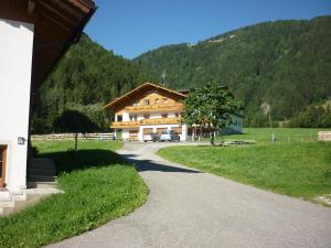 una strada che conduce a una grande casa in una montagna di Pension Wiesenhof a Campo di Trens