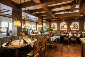 een restaurant met houten plafonds en tafels en stoelen bij AktiVital Hotel in Bad Griesbach