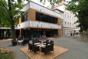 ein Gebäude mit Stühlen und Tischen davor in der Unterkunft Oxigén Family Hotel Noszvaj in Noszvaj