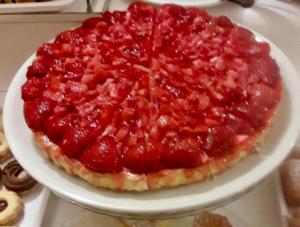 un pastel de fresa en un plato blanco en una mesa en Hotel Fortuna, en Caorle