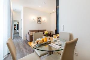 comedor y sala de estar con mesa de cristal y sillas en LETHESHOME Apartments, en Oporto