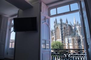 een open raam met uitzicht op een kathedraal bij Mosteiro View in Batalha