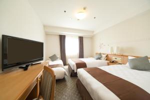 A bed or beds in a room at Osaka Tokyu REI Hotel