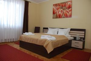 a bedroom with a large bed with towels on it at Villa Parc in Cluj-Napoca