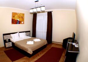 a bedroom with a bed and a window with towels at Villa Parc in Cluj-Napoca