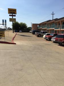 un parcheggio con auto parcheggiate di fronte a un hotel di Crown Inn Grand Prairie a Grand Prairie