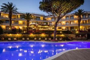 um hotel com piscina em frente a um edifício em Cala del Porto Punta Ala em Punta Ala