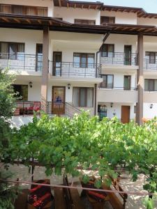 Un bâtiment avec une bande de plantes devant lui dans l'établissement Centaur Family Hotel, à Rila