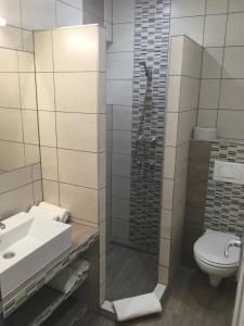 a bathroom with a shower and a toilet and a sink at Teke Bowling Centrum és Sport Panzió in Szeged