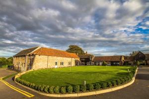 een oud stenen gebouw met een groen gazon ervoor bij Mendip Spring Golf and Country Club in Churchill