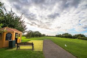 een park met een bankje naast een gebouw bij Mendip Spring Golf and Country Club in Churchill