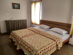 1 cama en un dormitorio con ventana y 1 cama sidx sidx sidx sidx en Aashraya Homestay, en Mysore